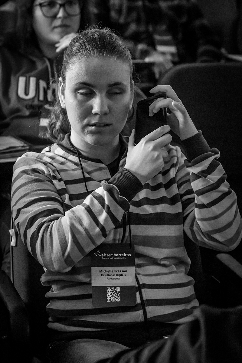 Michele no 1º Encontro do WSB com o celular na mão ao lado do ouvido direito, foto em preto e branco.